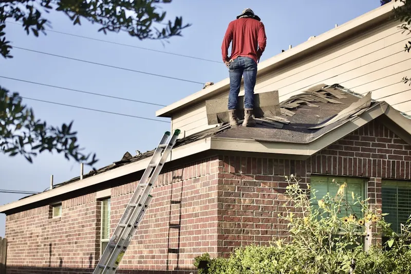 Professional roofer working on a residential roof in Country Club Colony